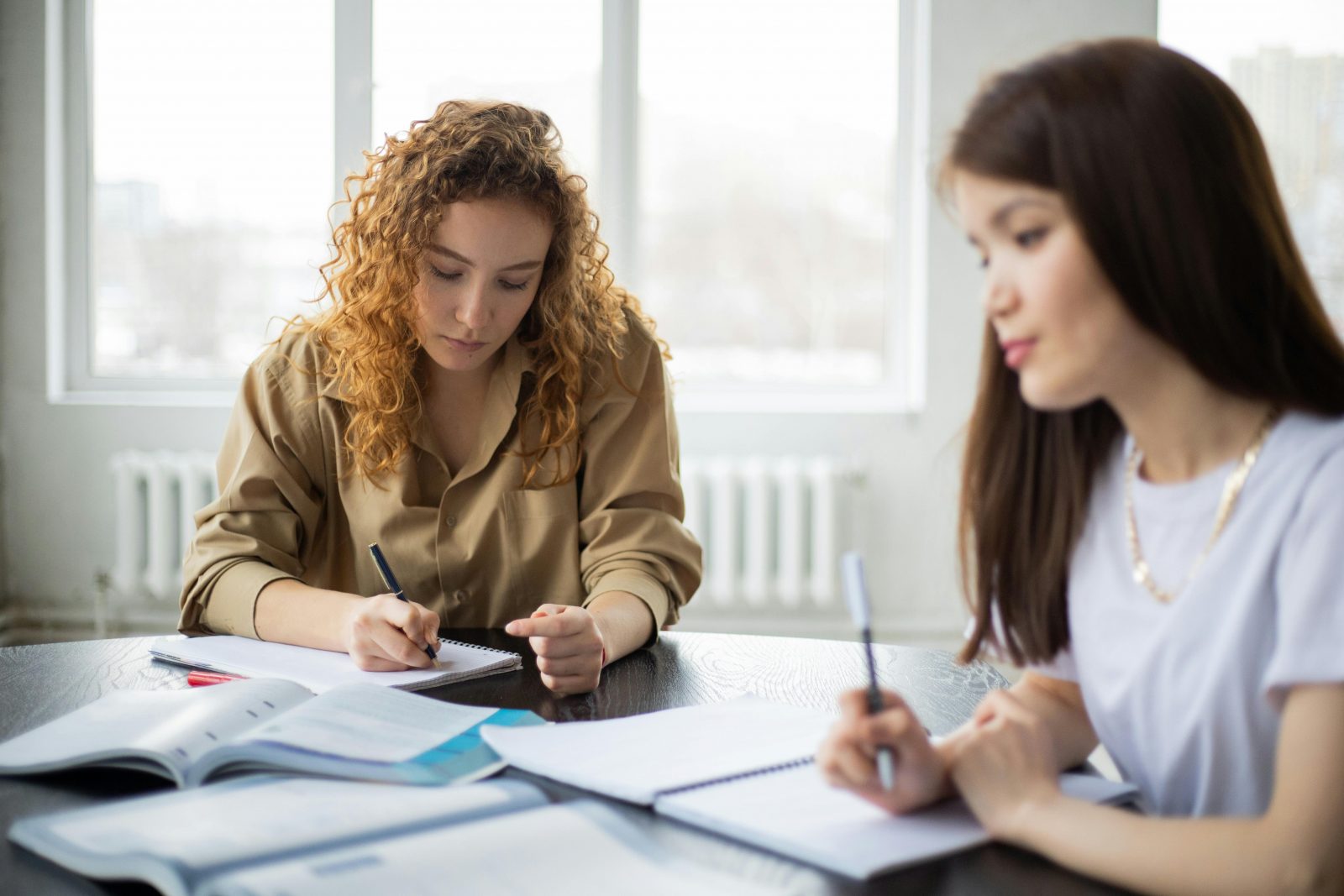 2 femmes qui font la technique du et si sur un bureau